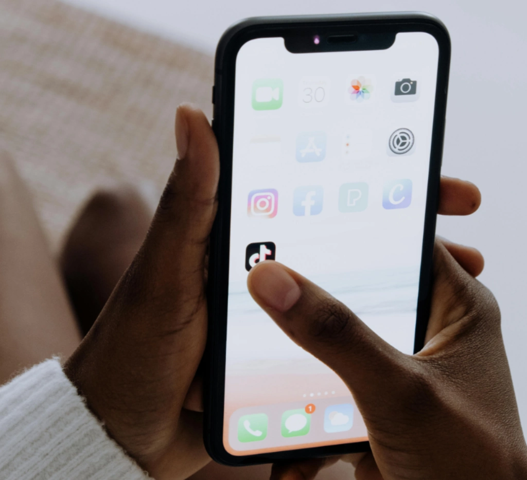 Person holding a smartphone with a digital shield and lock icon, symbolizing protection and security for online accounts like Instagram.